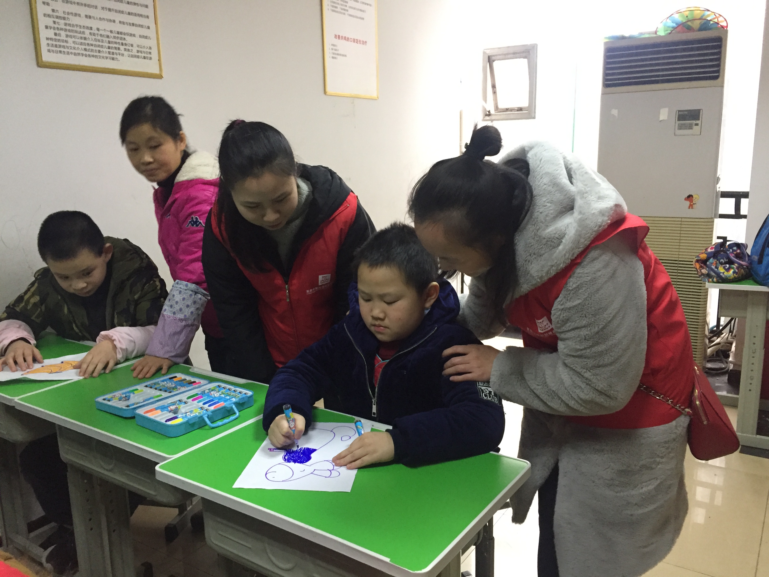 20181218-理林洲特殊教育学校-从“心”做起 关爱特殊儿童——重庆事业部开展志愿者服务活动-志愿者与孩子们一起完成课堂功课-谢梅摄.png